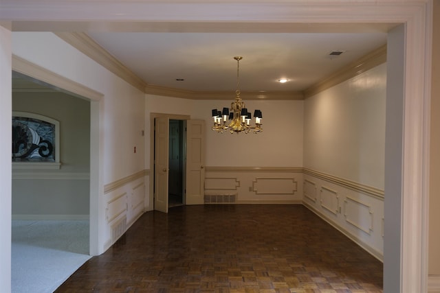 spare room featuring visible vents, a wainscoted wall, a notable chandelier, ornamental molding, and a decorative wall
