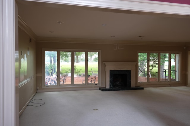unfurnished living room with a high end fireplace, carpet floors, and ornamental molding