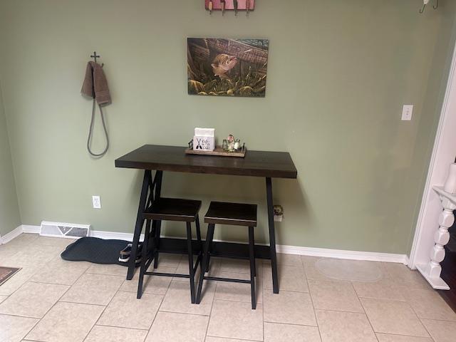 dining area featuring light tile patterned floors, baseboards, and visible vents