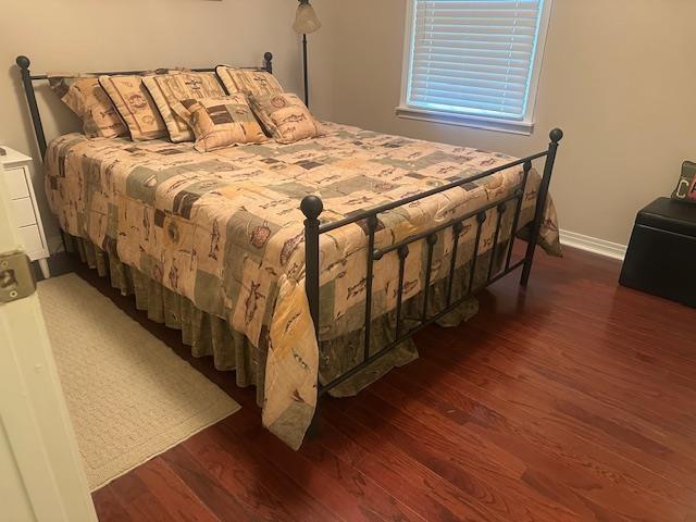 bedroom with baseboards and wood finished floors