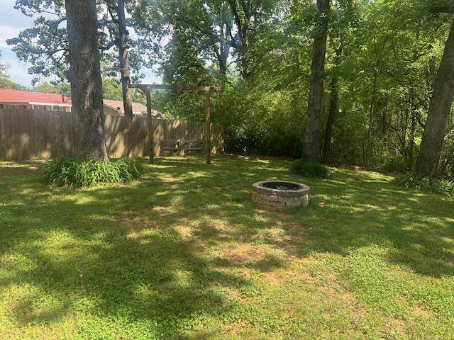 view of yard with fence and a fire pit