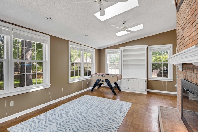 3365 Stone Creek Cv, Collierville, TN 38017 - interior space featuring crown molding, a fireplace, lofted ceiling with skylight, a textured ceiling, and a ceiling fan