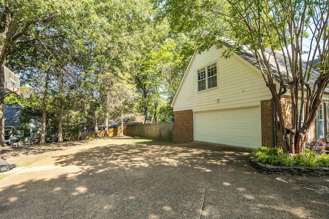 3365 Stone Creek Cv, Collierville, TN 38017 - view of side of property with brick siding, an attached garage, fence, and driveway
