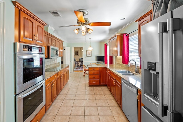 kitchen with visible vents, decorative backsplash, a peninsula, a sink, and stainless steel appliances