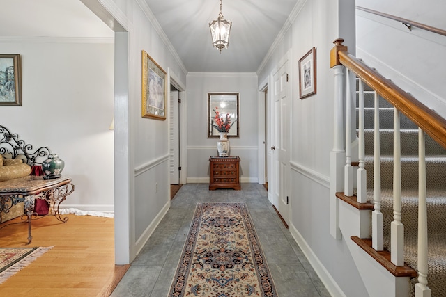 corridor featuring stairway, baseboards, ornamental molding, and an inviting chandelier