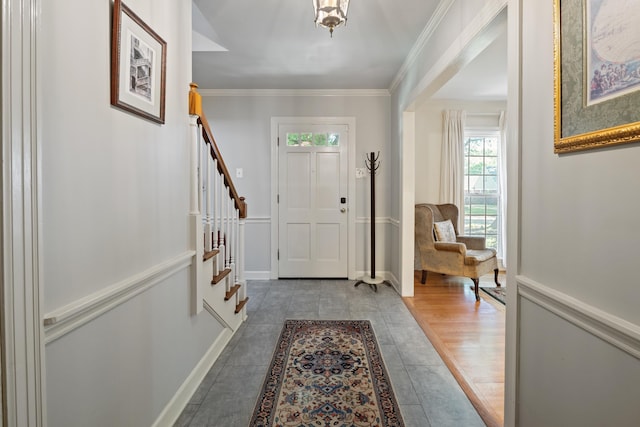 tiled entryway with baseboards, ornamental molding, and stairs