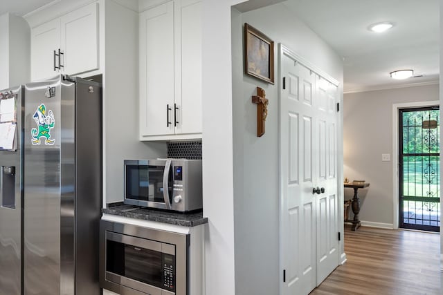 90 Shaker Dr, Senatobia, MS 38668 - kitchen with crown molding, wood finished floors, baseboards, white cabinetry, and stainless steel appliances
