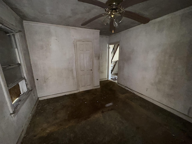 spare room with a ceiling fan and concrete floors