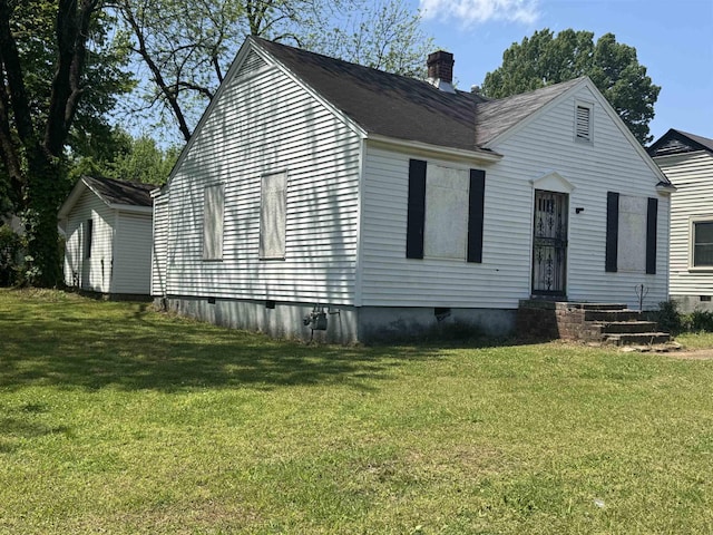 view of front of house with a chimney, a front yard, and crawl space