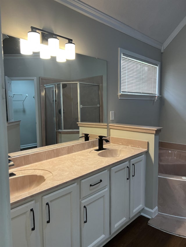 bathroom with a sink, double vanity, ornamental molding, a bath, and a stall shower