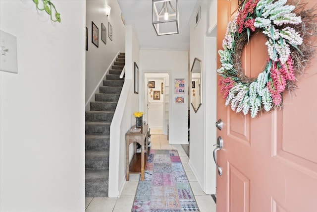 foyer with baseboards, visible vents, light tile patterned floors, and stairway