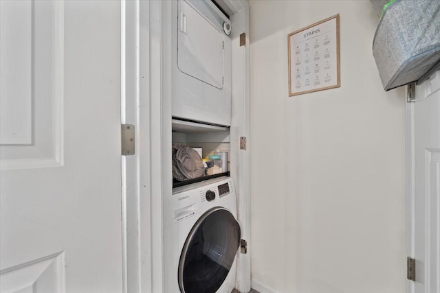 clothes washing area featuring laundry area and stacked washing maching and dryer