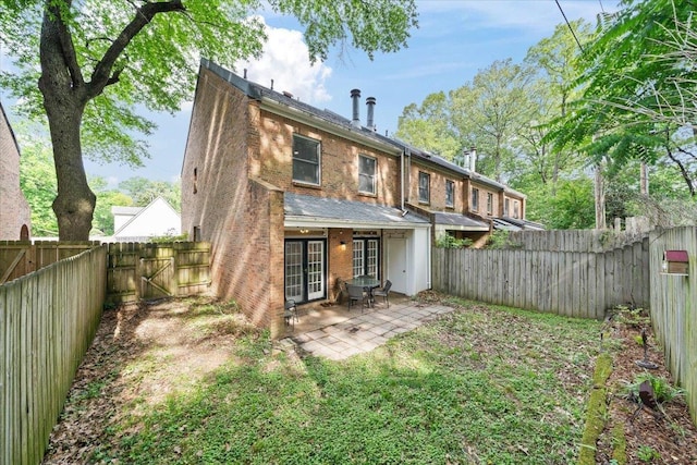back of property featuring a fenced backyard, a gate, a patio area, and brick siding