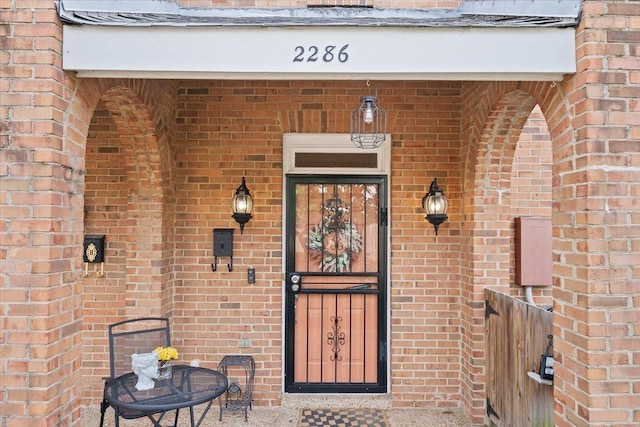 entrance to property featuring brick siding