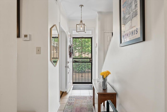 doorway to outside with crown molding and light tile patterned floors
