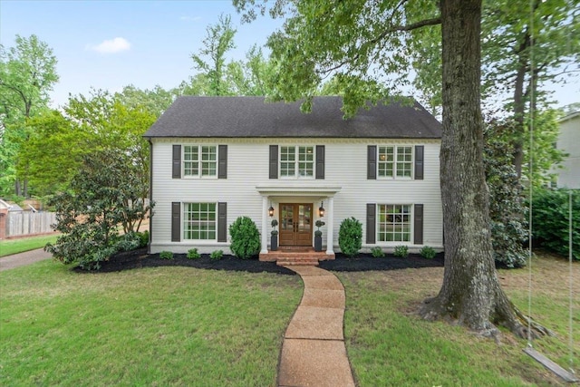 colonial-style house featuring french doors and a front yard