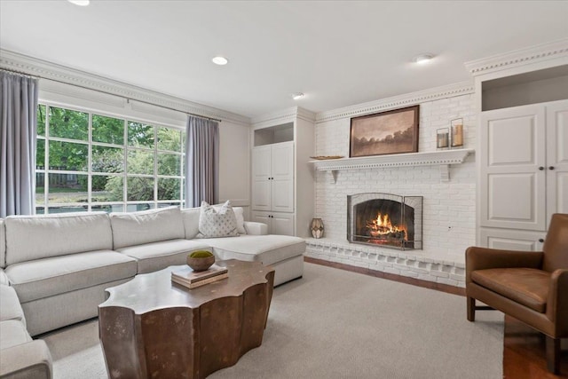 living room featuring a brick fireplace, recessed lighting, and ornamental molding