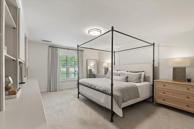 bedroom with baseboards, visible vents, and light carpet