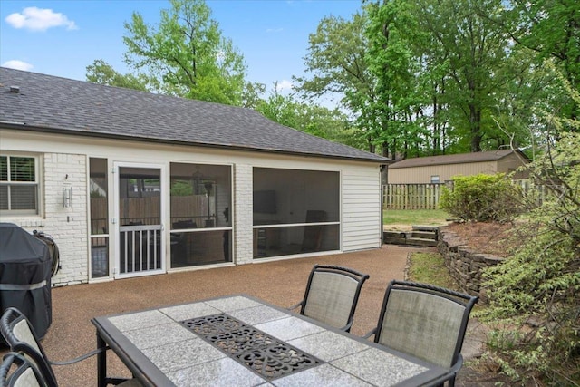 view of patio / terrace with fence, outdoor dining space, and a grill