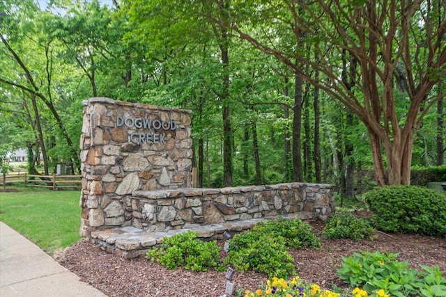 community / neighborhood sign featuring fence