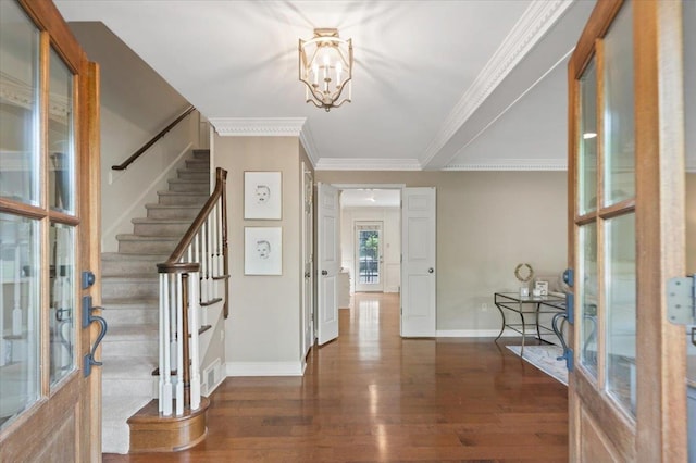 foyer entrance with baseboards, an inviting chandelier, wood finished floors, and stairway
