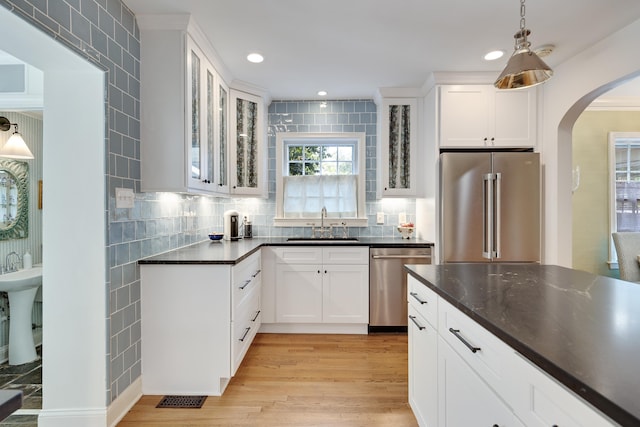 246 Palisade St, Memphis, TN 38111 - kitchen with a sink, dark countertops, white cabinetry, arched walkways, and appliances with stainless steel finishes