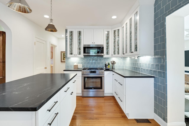 246 Palisade St, Memphis, TN 38111 - kitchen with appliances with stainless steel finishes, arched walkways, recessed lighting, decorative backsplash, and light wood-type flooring