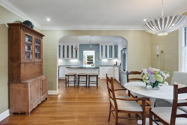 246 Palisade St, Memphis, TN 38111 - dining area with crown molding, arched walkways, and light wood finished floors