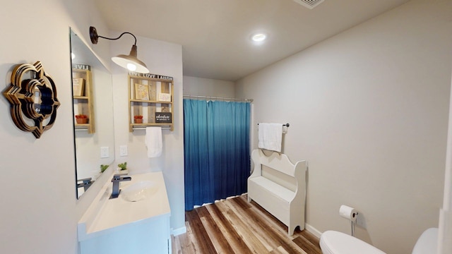 bathroom with vanity, wood finished floors, toilet, a shower with shower curtain, and recessed lighting