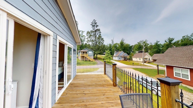 wooden terrace with a residential view and a lawn