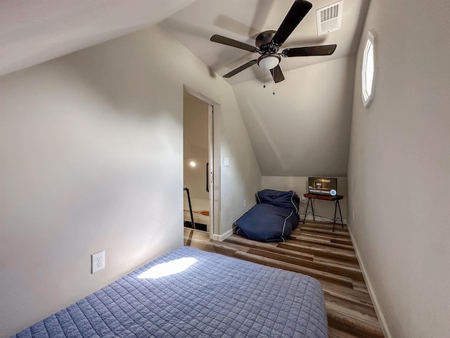 bedroom with visible vents, lofted ceiling, wood finished floors, baseboards, and a ceiling fan