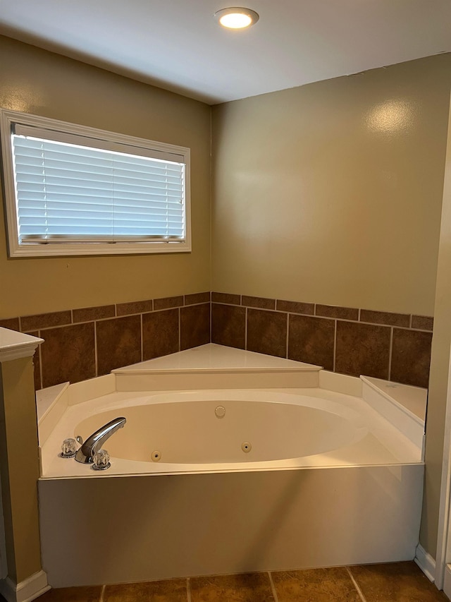 full bath featuring a whirlpool tub and tile patterned flooring