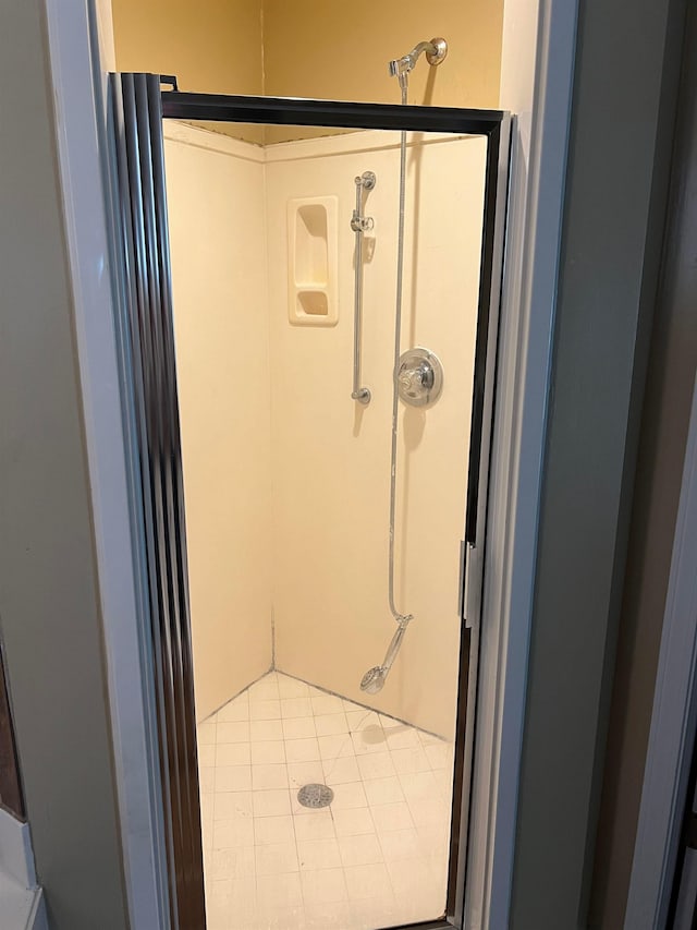 full bath featuring tile patterned floors and a shower stall