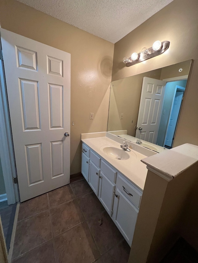 bathroom featuring a textured ceiling, tile patterned flooring, and vanity