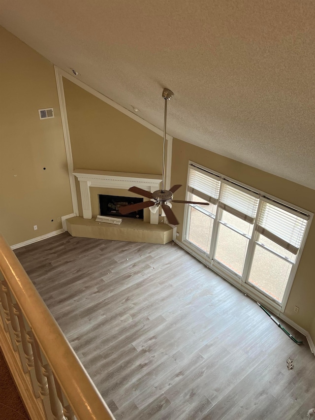 unfurnished living room featuring a textured ceiling, wood finished floors, and visible vents