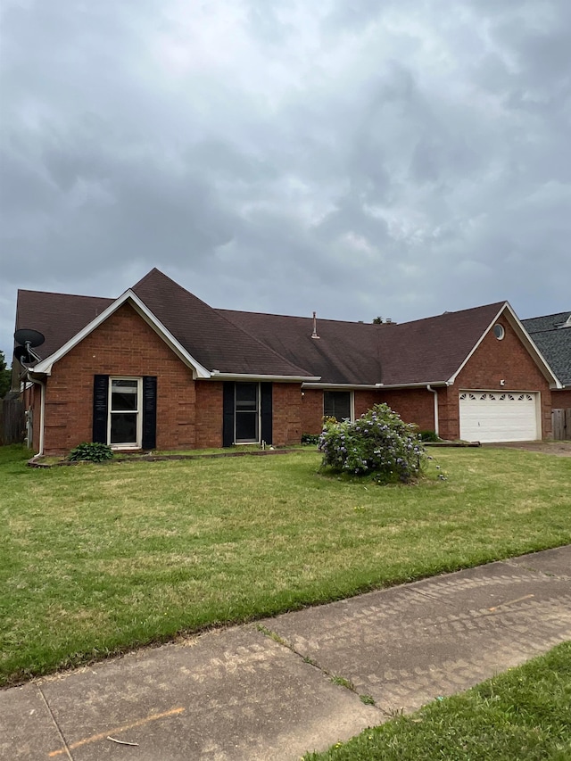 single story home with roof with shingles, an attached garage, brick siding, and a front yard