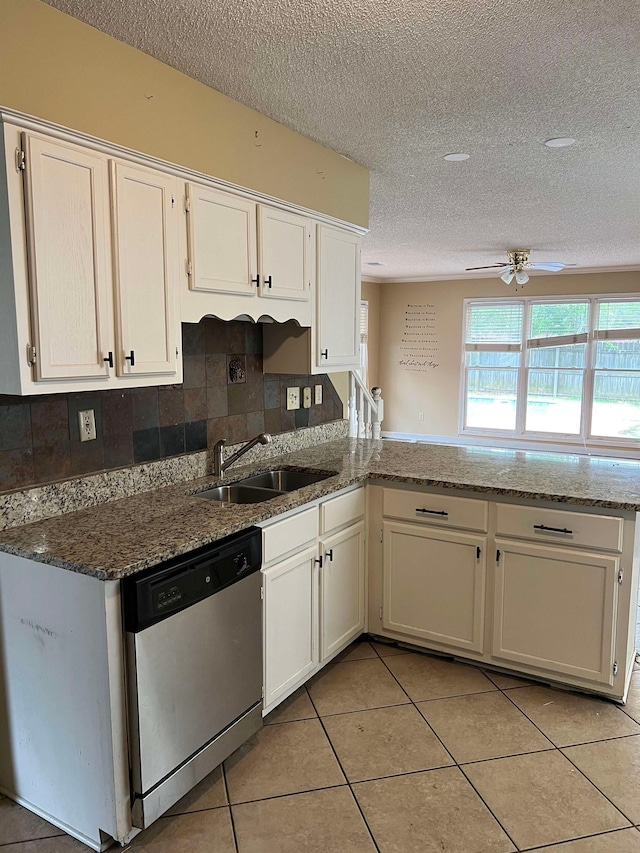 kitchen with a peninsula, a textured ceiling, a sink, and dishwasher