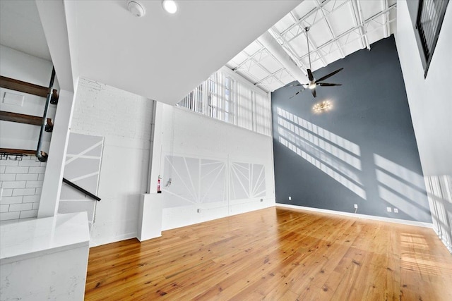 415 S Front St Unit 110, Memphis, TN 38103 - unfurnished living room with a ceiling fan, stairs, a towering ceiling, and hardwood / wood-style floors