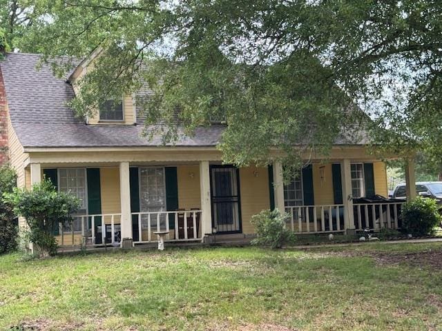 back of house with a shingled roof, a yard, and a porch