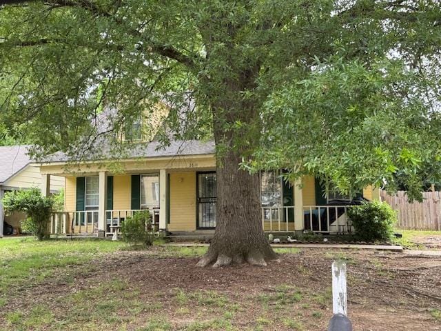 view of front facade featuring fence and a porch