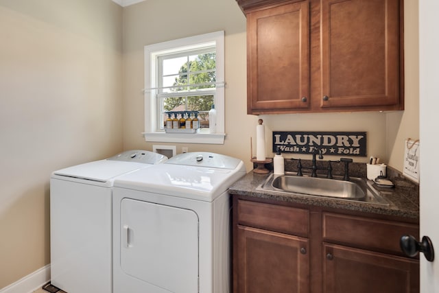clothes washing area featuring a sink, cabinet space, and washing machine and dryer