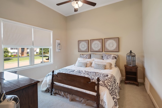 bedroom featuring light colored carpet, a ceiling fan, baseboards, and crown molding