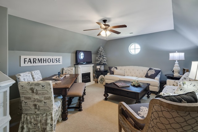 living area with a ceiling fan, visible vents, a fireplace, lofted ceiling, and light carpet