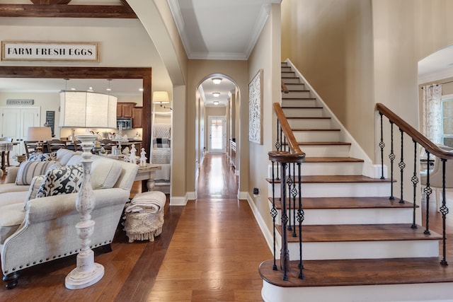 foyer entrance featuring arched walkways, plenty of natural light, and dark wood-style flooring