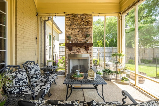 sunroom / solarium with a stone fireplace