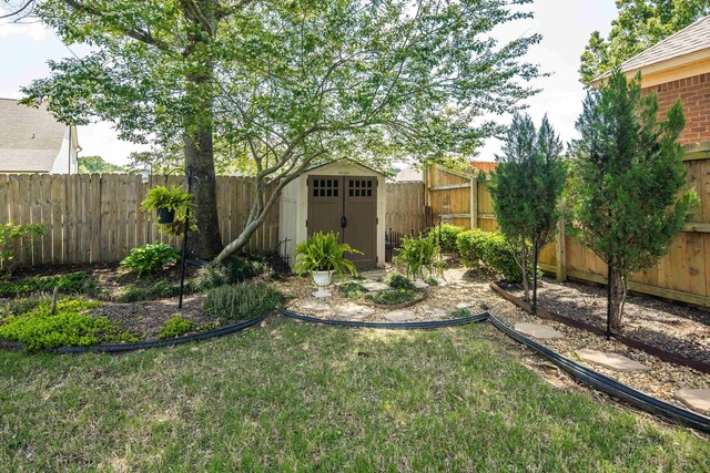 view of yard featuring an outdoor structure, a fenced backyard, and a shed