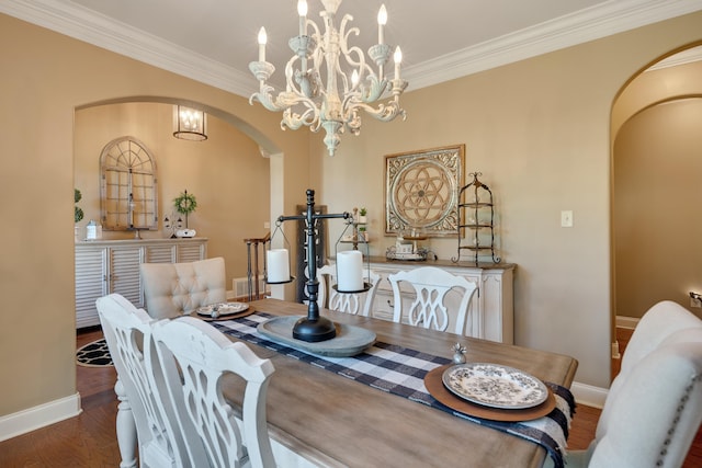 dining space with arched walkways, baseboards, ornamental molding, and wood finished floors