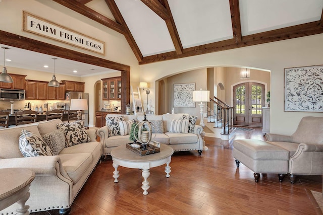 living room with beam ceiling, arched walkways, high vaulted ceiling, french doors, and dark wood-type flooring