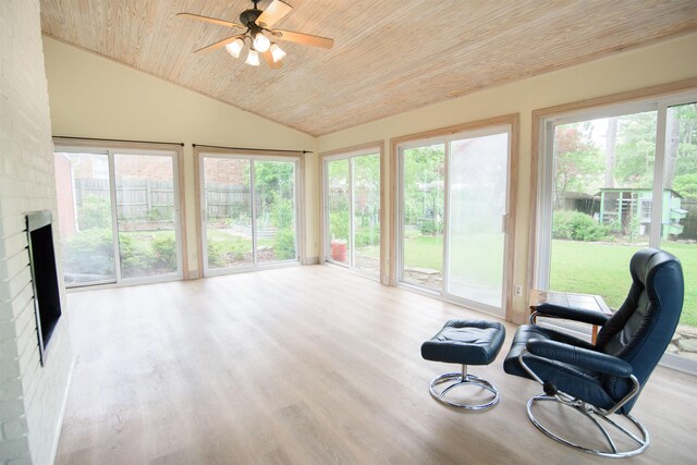 sunroom with vaulted ceiling, wooden ceiling, a healthy amount of sunlight, and wood finished floors