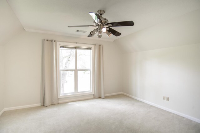 empty room with visible vents, lofted ceiling, baseboards, ceiling fan, and carpet flooring